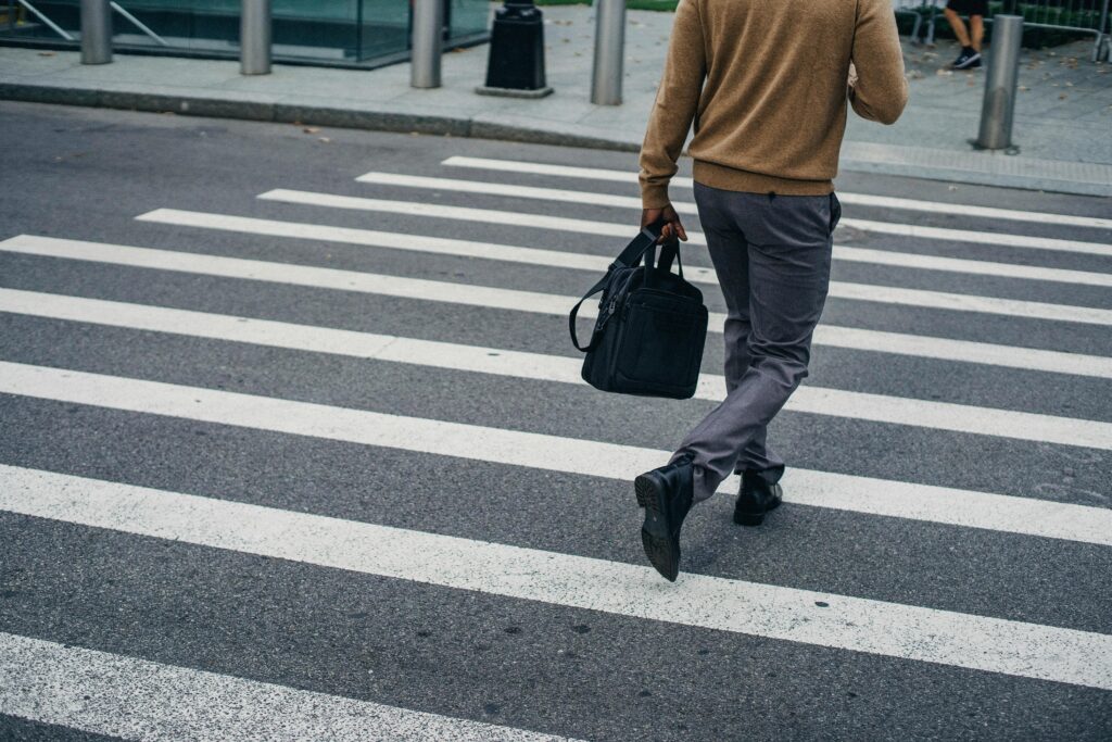 Person crossing road representing pedestrian personal injury claims and contributory negligence