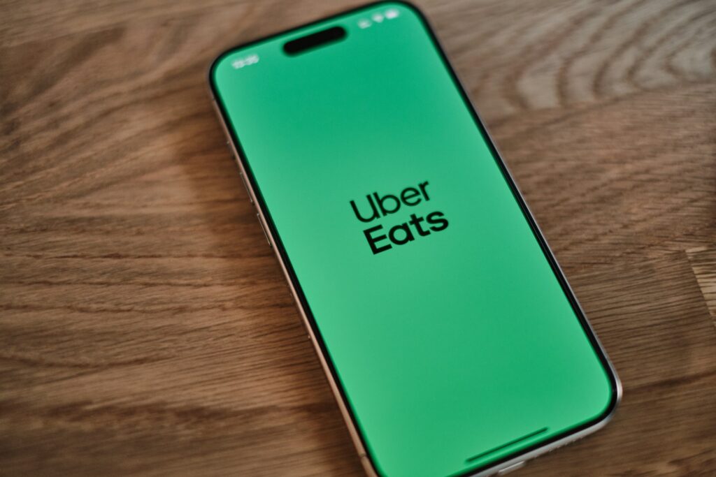Uber Eats app on a smartphone resting on a table, representing consumer protection and subscription services.