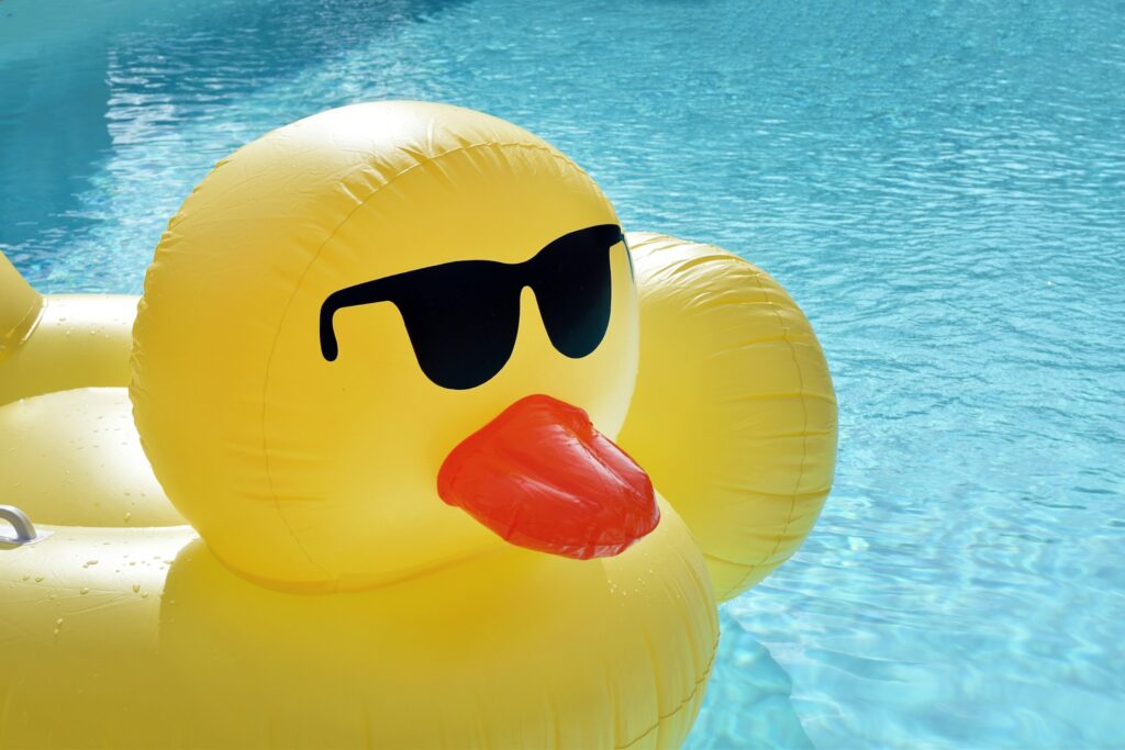 A duck-shaped flotation device in a pool, representing summer injuries.