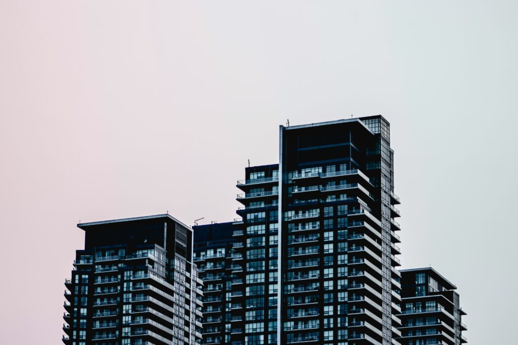 View of modern-style glass condominium towers against a grey skyline, representing condominium liens in Ontario.