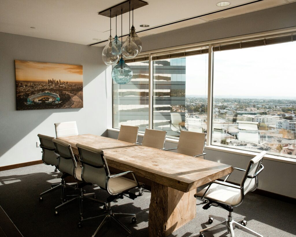A wooden conference table and chairs next to a wall of windows, representing a breach of fiduciary duty.